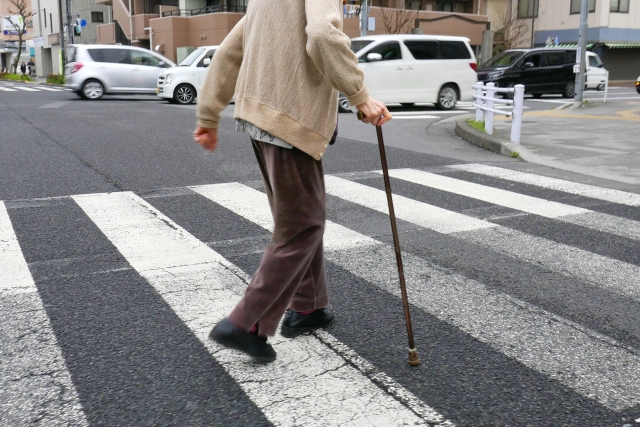 杖を突いて歩く老人